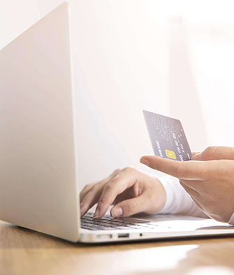 Person-on-laptop-with-a-credit-card-in-hand