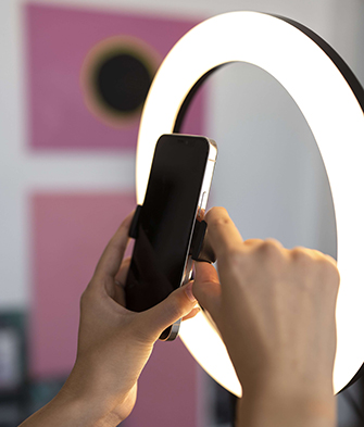 Person-filming-on-their-phone-with-a-ring-light