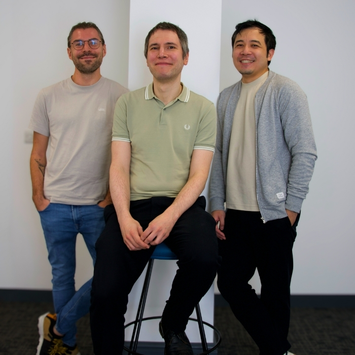 Three-colleagues-standing-next-to-each-other