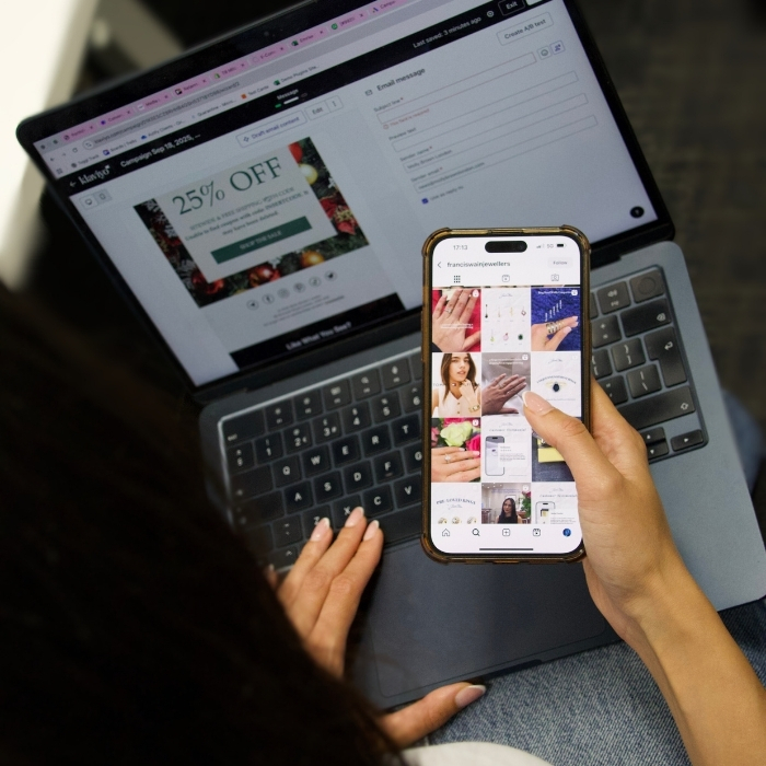 Person holding a phone and laptop