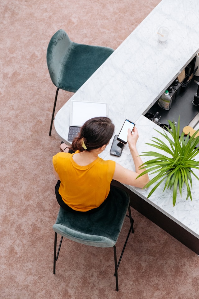 Woman-using-smartphone-and-laptop-to-research-products-online.